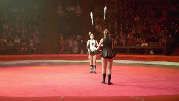 Het duo van tweeling meisjes jongleren met clubs voert trucs uit op het Circus podium — Stockvideo