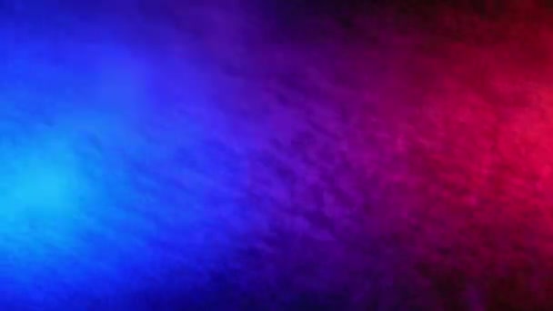 Pulvérisation d'eau rouge et bleue mélangée sur un fond noir. Mouvement lent 