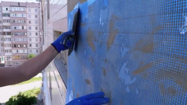 Industriële klimmer met behulp van Trowel Putty Glue op glasvezel Mesh te isoleren gevel — Stockvideo