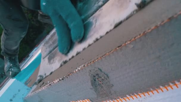Escalador industrial que usa pegamento de masilla de paleta en malla de fibra de vidrio para aislar la fachada — Vídeo de stock