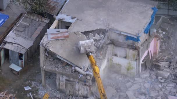 Destruyendo la vieja casa usando excavadora de cubo en el sitio de construcción . — Vídeo de stock