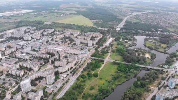 Воздушная панорама города с многоэтажными зданиями недалеко от природы и реки — стоковое видео
