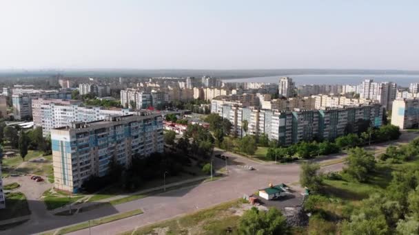 Воздушная панорама жилых блоков многоэтажных зданий вблизи реки и природы — стоковое видео