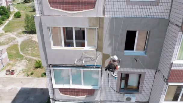 Vista aérea Escalador industrial Realizar trabajos en el edificio de fachada lateral de aislamiento — Vídeo de stock