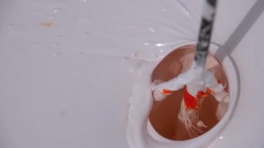 Kova 'da Beyaz ve Kırmızı Boya' yı çırpılmış çırpı kullanarak karıştırmak. Yavaş Hareket