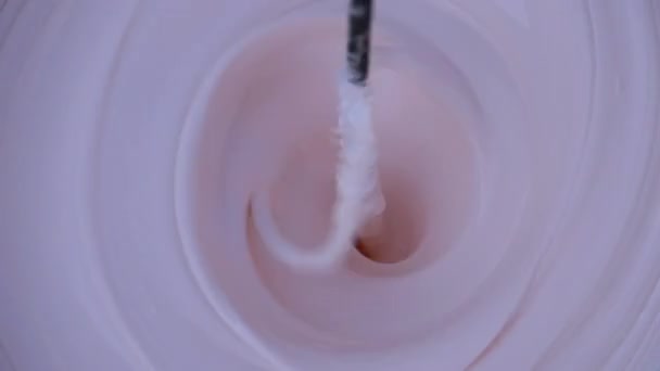 Смешивание белого с красной краской в ведре с помощью Whisk on a Drill. Slow Motion — стоковое видео