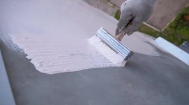 Endüstriyel dağcı boya fırçasıyla duvarları beyaz boyayla boyuyor. Yavaş Hareket