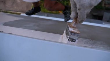 Endüstriyel dağcı boya fırçasıyla duvarları beyaz boyayla boyuyor. Yavaş Hareket