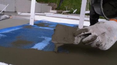 Endüstriyel dağcı, fiberglas örgü üzerinde Trowel macunu yapıştırıcısı kullanarak dış cepheyi izole ediyor.