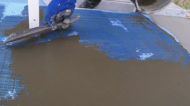 Endüstriyel dağcı, fiberglas örgü üzerinde Trowel macunu yapıştırıcısı kullanarak dış cepheyi izole ediyor.