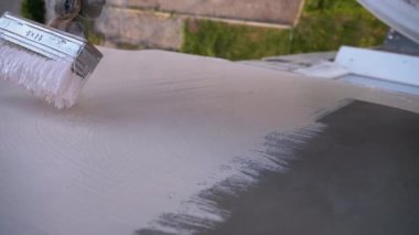 Endüstriyel dağcı boya fırçasıyla duvarları beyaz boyayla boyuyor. Yavaş Hareket