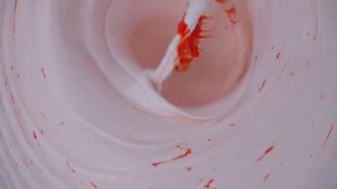 Kova 'da Beyaz ve Kırmızı Boya' yı çırpılmış çırpı kullanarak karıştırmak. Yavaş Hareket