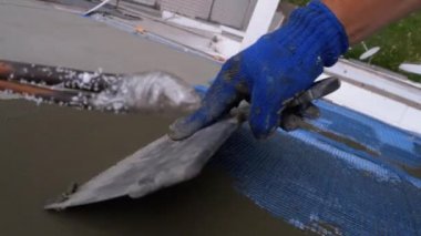 Endüstriyel dağcı, fiberglas örgü üzerinde Trowel macunu yapıştırıcısı kullanarak dış cepheyi izole ediyor.