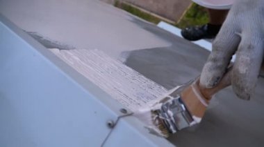 Endüstriyel dağcı boya fırçasıyla duvarları beyaz boyayla boyuyor. Yavaş Hareket