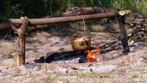 Cuisiner sur un feu ouvert dans un pot de tourisme. Chapeau de joueur de bowling touristique pendu à Bonfire — Video