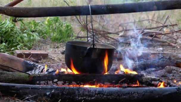 Vaření na otevřeném ohni v Turistickém hrnci. Turistický bowler klobouk visí na Bonfire — Stock video