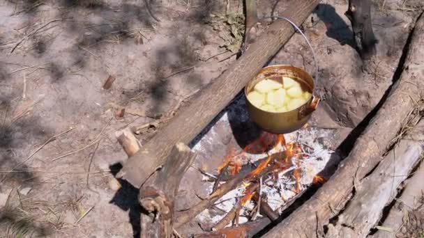 Cuisiner sur un feu ouvert dans un pot de tourisme. Chapeau de joueur de bowling touristique pendu à Bonfire — Video
