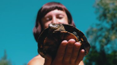 Kadın Yeşil Sebzeli Komik Kaplumbağayı Tutuyor ve Nehirde Gülümsüyor