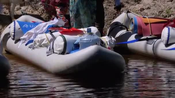 Rafting Łodzie z rzeczami turystycznymi i przepisy zaparkowane wzdłuż brzegu rzeki — Wideo stockowe