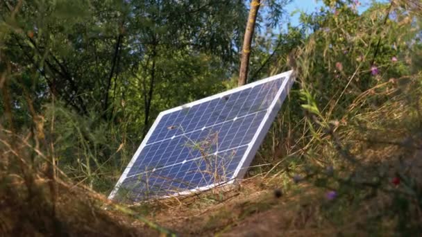 Przenośny panel słoneczny leżący na terenie wykorzystywanym w turystyce i na kempingu — Wideo stockowe