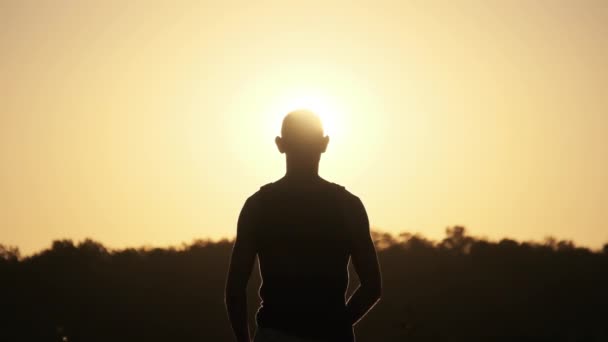Silueta mladého muže skákajícího s rukama na stranu při západu slunce. Pomalý pohyb 240 fps. — Stock video
