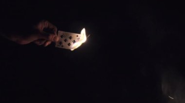 Doğa 'da Kamp Ateşi' nin yakınındaki Kara Arkaplanda El Yakma Kartı. Yavaş çekim