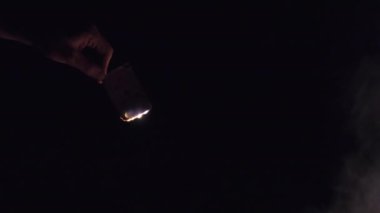 Doğa 'da Kamp Ateşi' nin yakınındaki Kara Arkaplanda El Yakma Kartı. Yavaş çekim