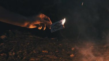 Doğa 'da Kamp Ateşi' nin yakınındaki Kara Arkaplanda El Yakma Kartı. Yavaş çekim