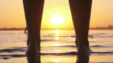 Plajda Sunset 'te Kadın Bacakları' nın Silueti Suda Duruyor. Yavaş Hareket