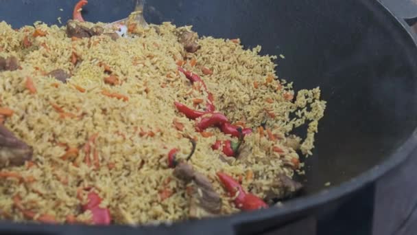 Großer Bottich mit gekochtem Pilaf oder Reis über offenem Feuer. Street Food auf der Party — Stockvideo
