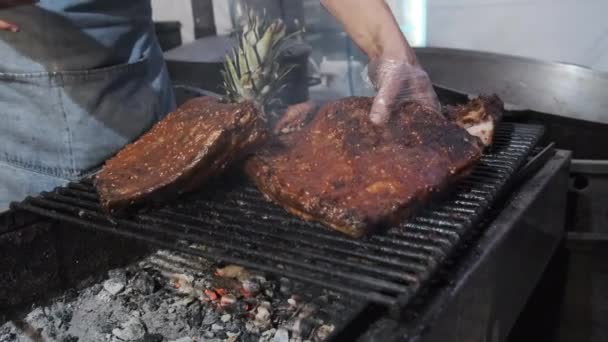 A carne é grelhada no Street Food Festival. Grandes pedaços de carne de porco assada no churrasco — Vídeo de Stock