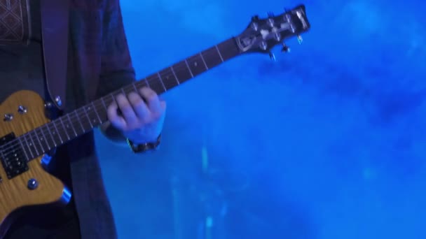 Guitarrista en un concierto de rock toca guitarra eléctrica en el escenario abierto. Moción lenta — Vídeos de Stock