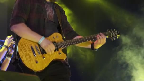 Гитарист на рок-концерте играет на электрогитаре на открытой сцене. Slow Motion — стоковое видео