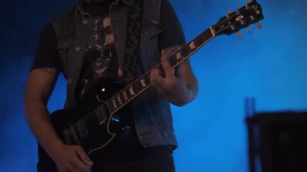 Kytarista na rockovém koncertě hraje na elektrickou kytaru na otevřeném pódiu. Pomalý pohyb