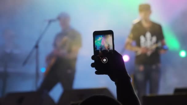 ライブロックコンサートでビデオを作るスマートフォンと男性の手.スローモーション — ストック動画