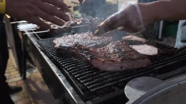 A húst grillezik a Street Food Fesztiválon. Nagy darab sertés sült a BBQ — Stock videók