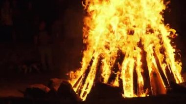 Gece Partisinde Büyük Şenlik Ateşi Etrafındaki İnsanlar. Ağır çekim. Büyük Yangın Arkaplanı