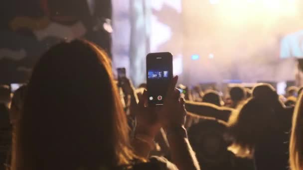 Silhouette of Woman Hands machen Video mit Smartphone bei Live Rock Concert. Zeitlupe — Stockvideo