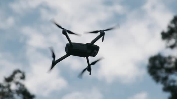 Dron visí ve vzduchu proti modrému nebi, pohled zdola. Pomalý pohyb 240 fps — Stock video