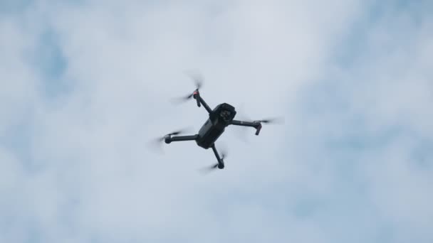 Drone cuelga en el aire contra el cielo azul, Vista desde abajo. Moción lenta — Vídeos de Stock