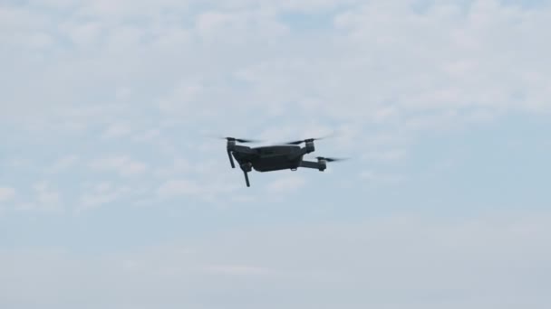 Беспилотник висит в воздухе против Голубого неба, вид снизу. Slow Motion — стоковое видео