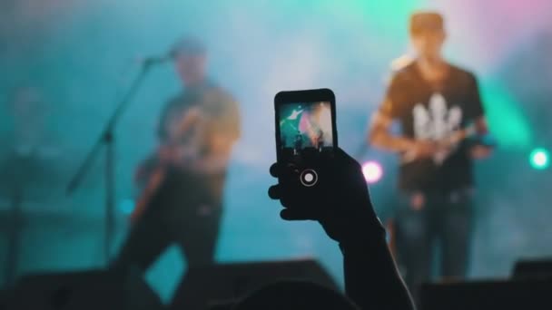 Мужчина со смартфоном в Hand Making Video на концерте Live Rock. Slow Motion — стоковое видео