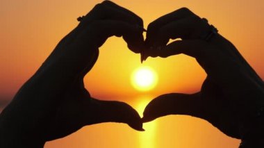 Turuncu Gün Batımında Bir Kalp Şeklinde Kadın Ellerinin Silüeti