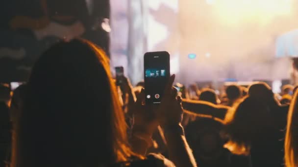 Женщина руки силуэт Запись видео концерта живой музыки со смартфоном — стоковое видео