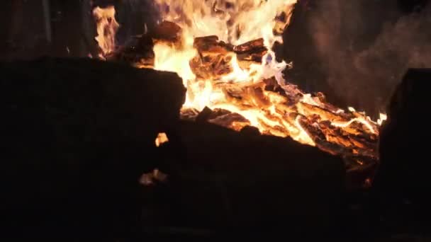 Heiße Kohlen brennen ein großes Feuer nieder und leuchten leuchtend rot. Zeitlupe — Stockvideo