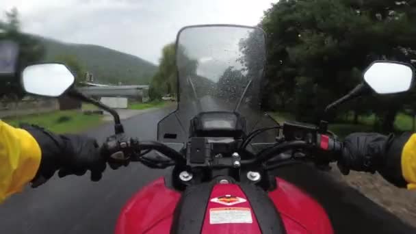 Motociclista en paseos en bicicleta en una carretera de montaña de paisaje bajo la lluvia — Vídeos de Stock