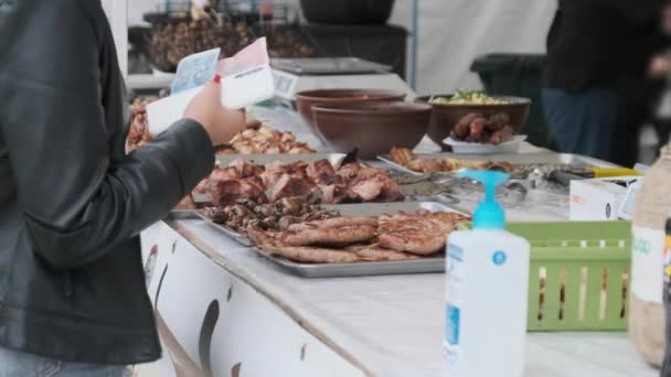 Comprador compra comida grelhada e transfere dinheiro para o vendedor em um festival de rua — Vídeo de Stock