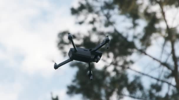 Drone cuelga en el aire contra el cielo azul, Vista desde abajo. Moción lenta 240 fps — Vídeo de stock