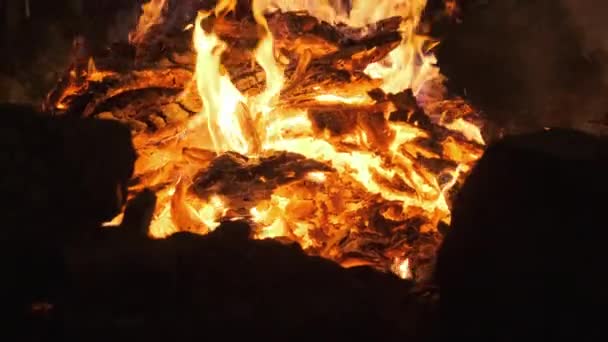 Heiße Kohlen brennen ein großes Feuer nieder und leuchten leuchtend rot. Zeitlupe — Stockvideo