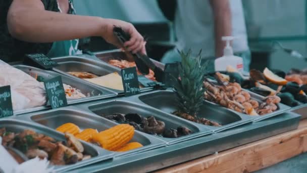 El vendedor está vendiendo varios alimentos callejeros a la parrilla Verduras y carne en las cortes de comida. — Vídeos de Stock